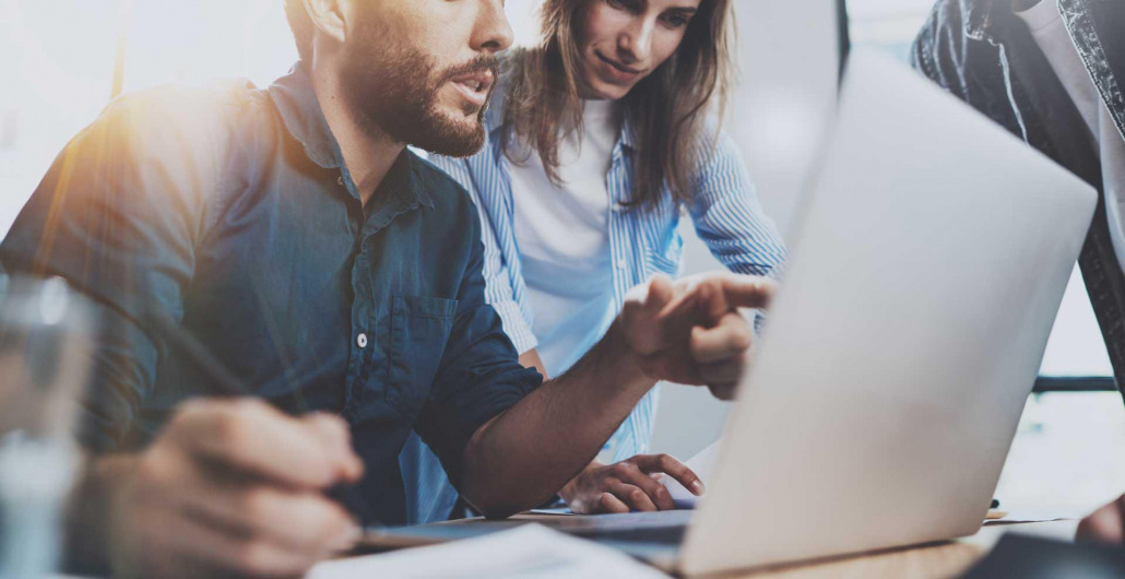 man and woman looking and pointing at laptop