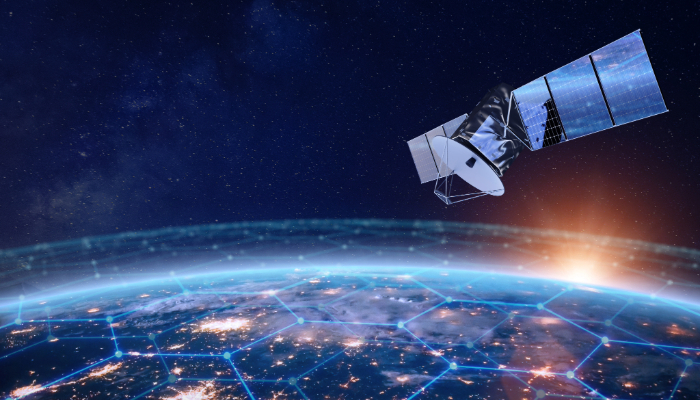 Earth from space with a satellite flying over, and blue digital network lines overlaying the planet