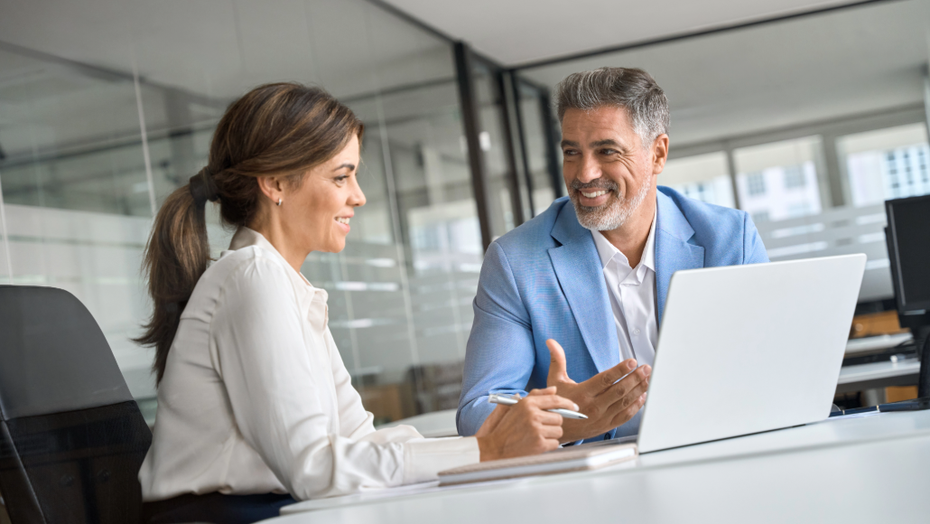 Woman and man discussing in front of a laptop