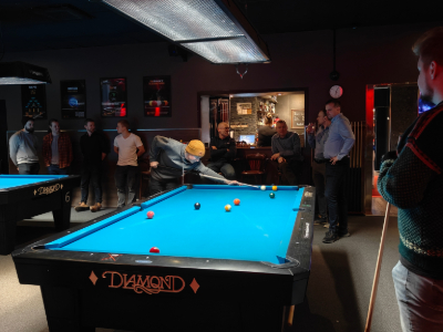Magisterians gathered around a pool table