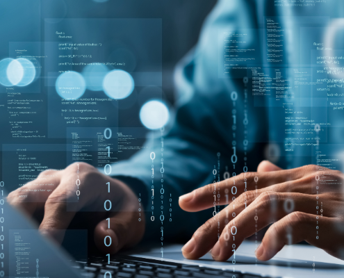 Software development Fingers typing on a computer keyboard with blue-colored representations of code and data overlaid